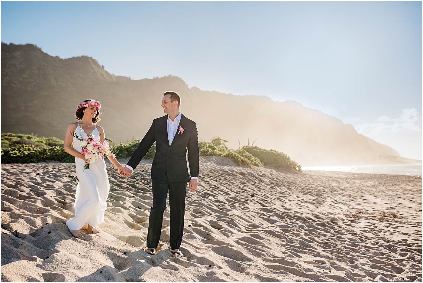 bride and groom at the beach walking to oahu elopement ceremony