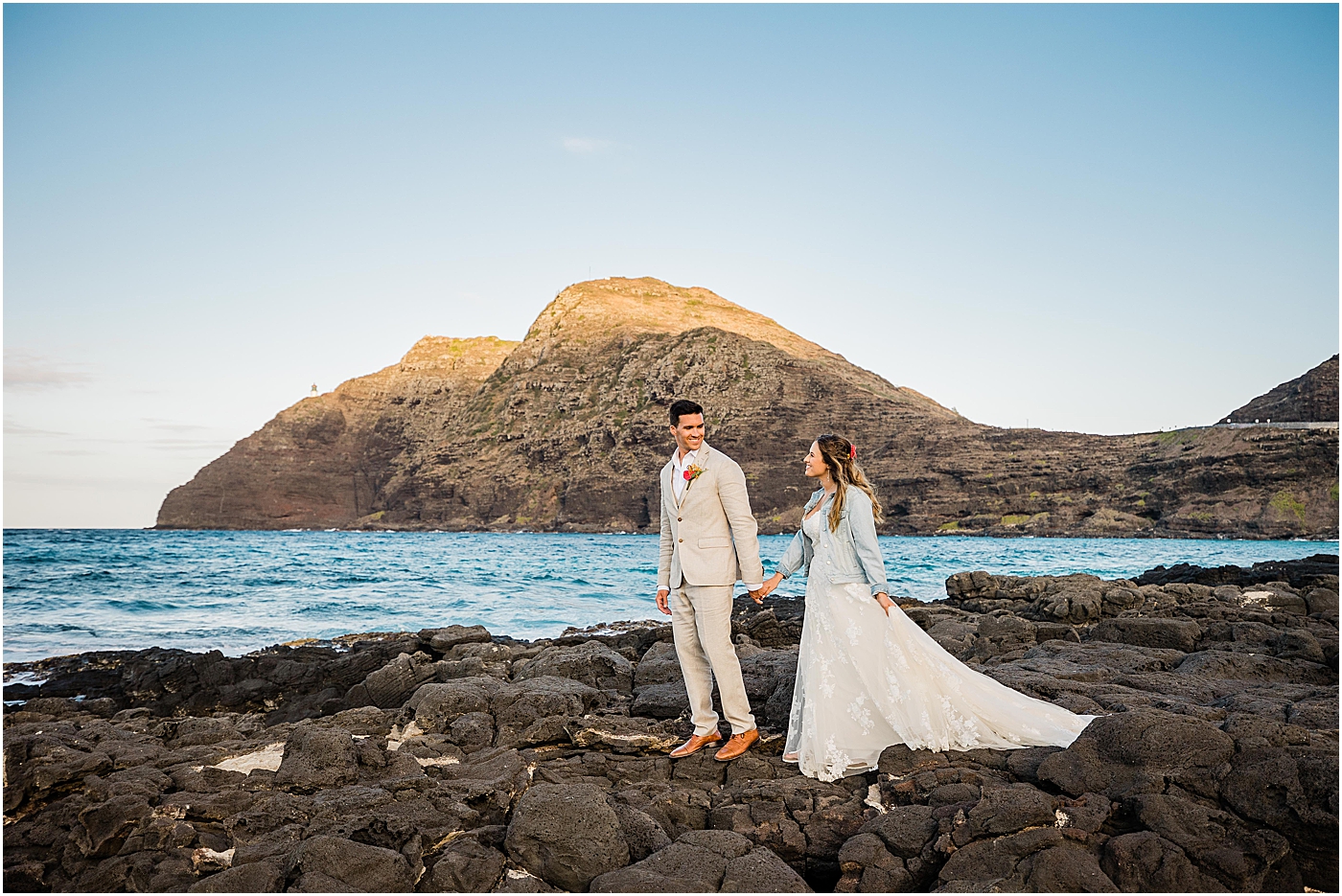 bride and groom on rocks in wedding in hawaii