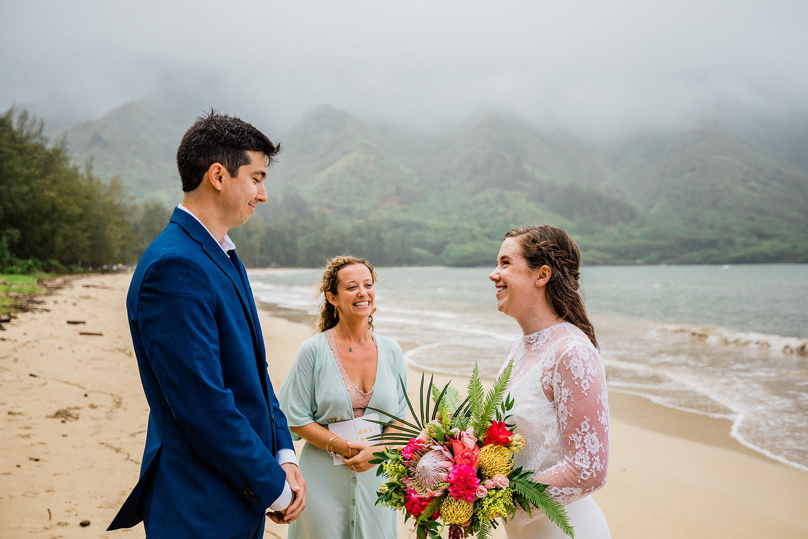 bride, groom, and officiant during hawaii elopement ceremony on the beach