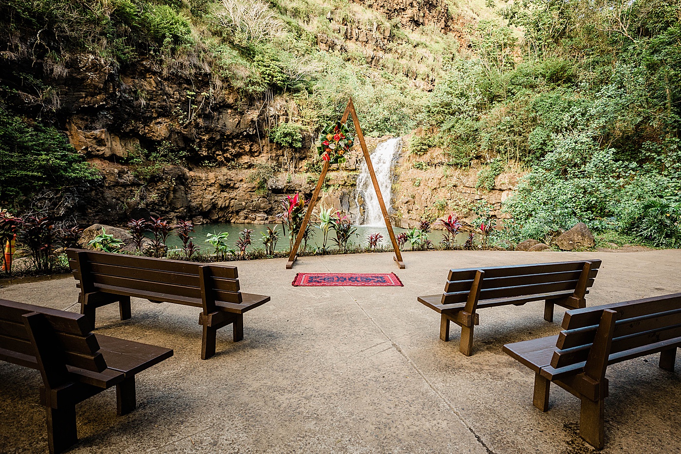 Bench and arch set up in front of waterfall at Waimea Valley wedding.
